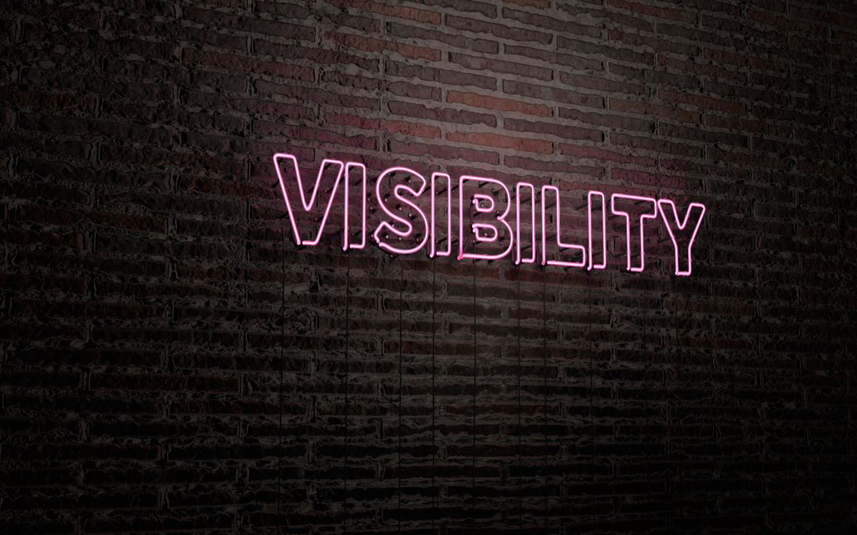 Neon visibility sign on brick wall